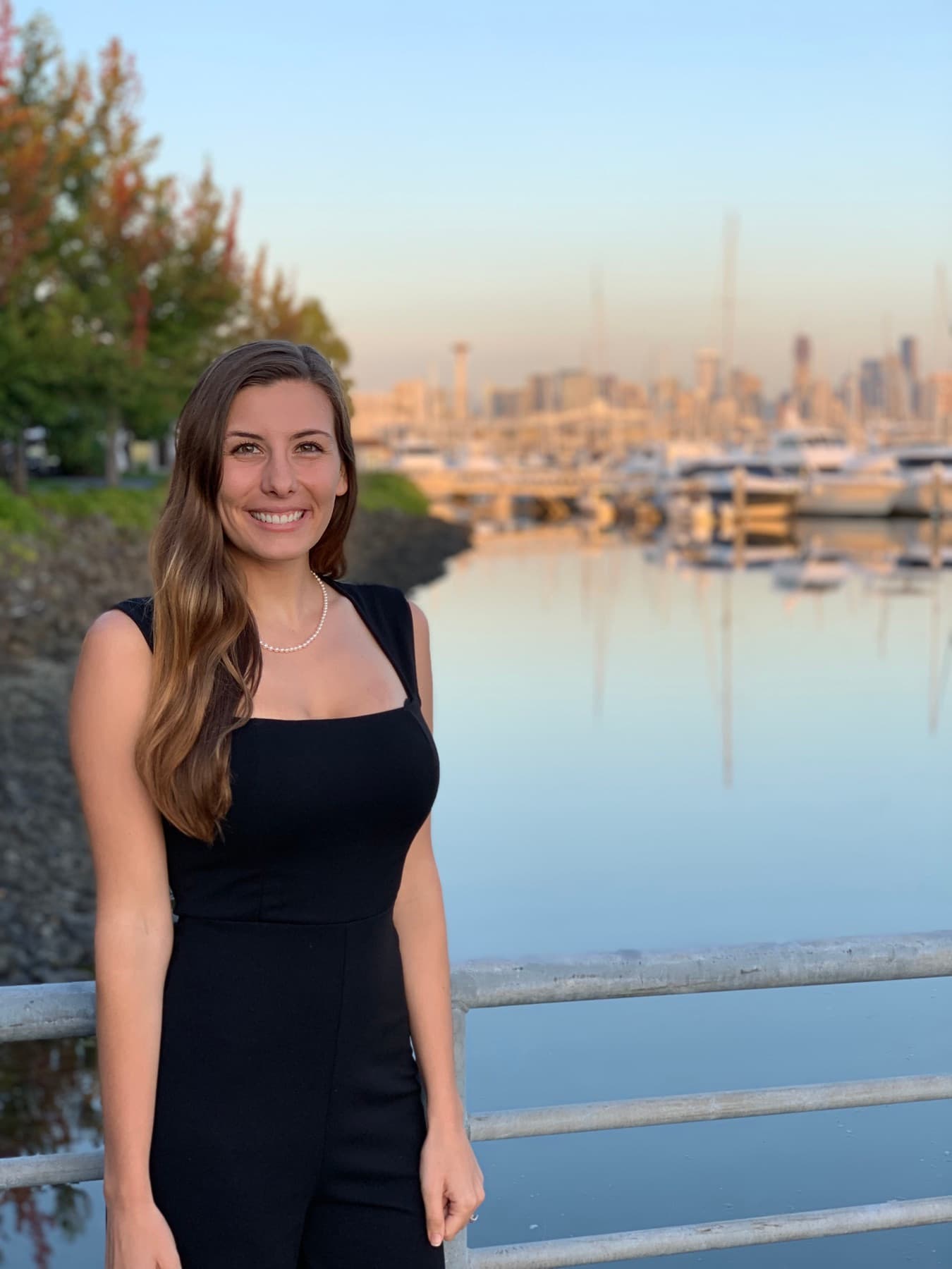 Annie Mewborn on the Seattle waterfront at golden hour, the city skyline behind her.